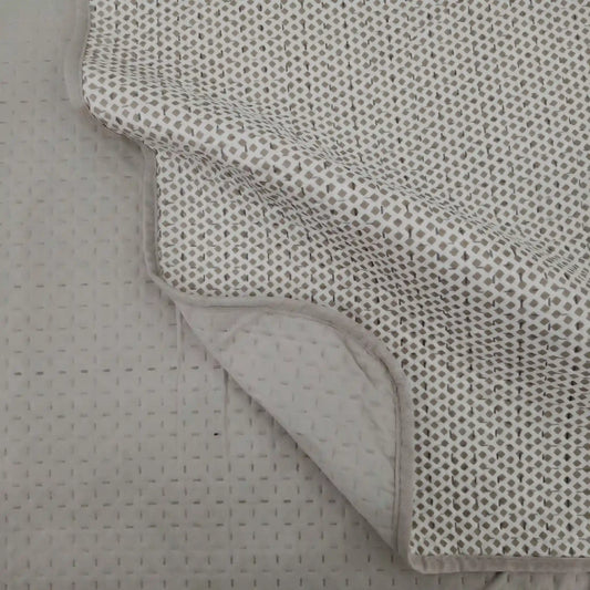 Detalle de la esquina de la colcha reversible estampada con rombos