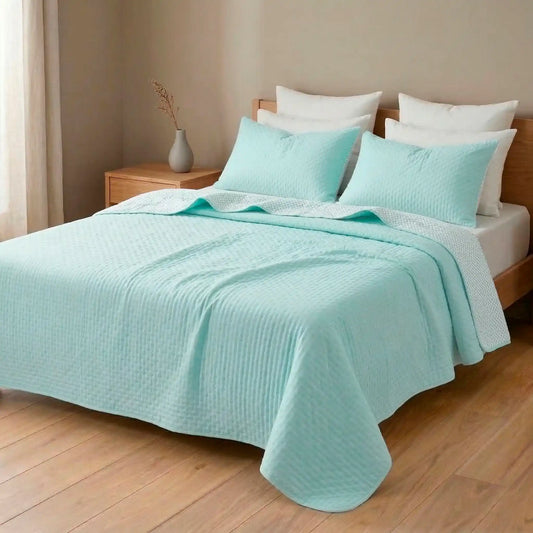 Colcha reversible color verde agua de verano mostrando su reverso blanco estampado