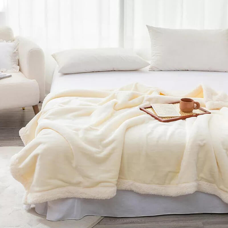 Manta borreguito extra suave reversible con borde. Color blanco roto.