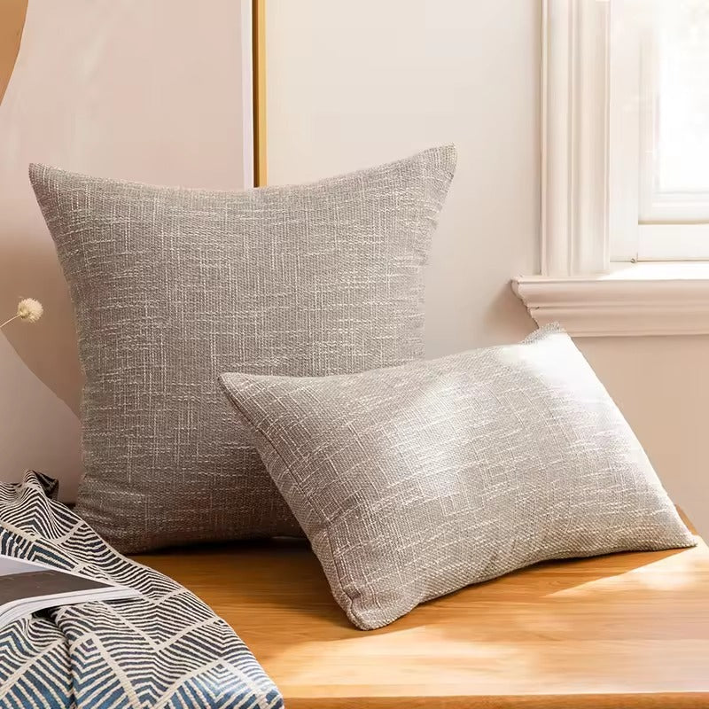 Smooth light gray cushion cover with relief.