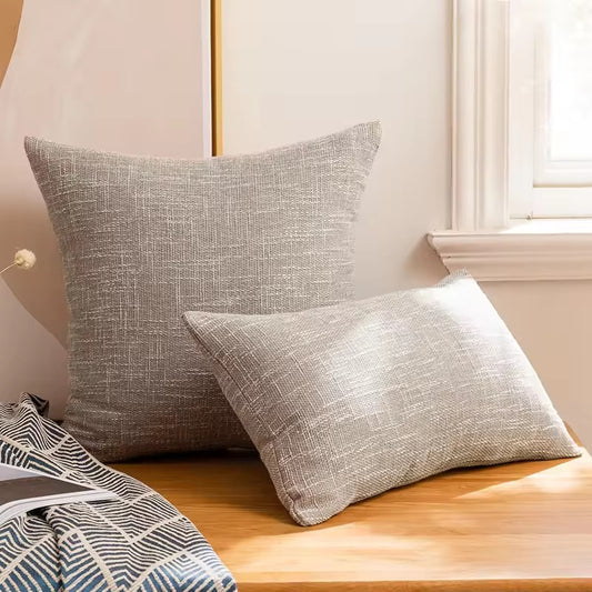 Smooth light gray cushion cover with relief.