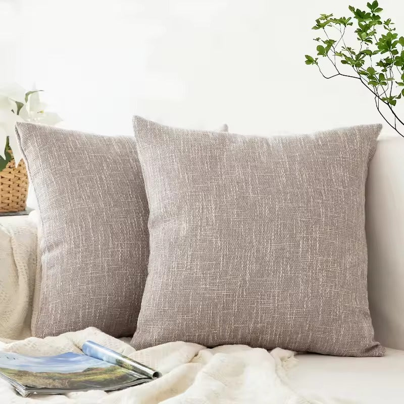 Smooth light gray cushion cover with relief.