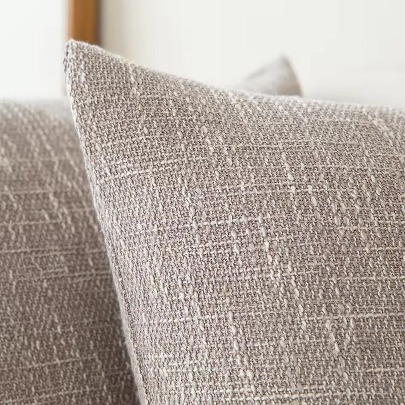 Smooth light gray cushion cover with relief.