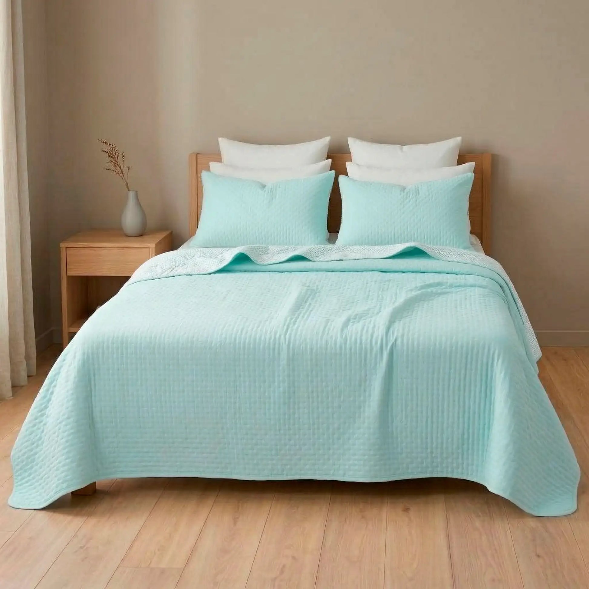 Cama decorada con colcha bouti de verano en tono aguamarina fresco y luminoso