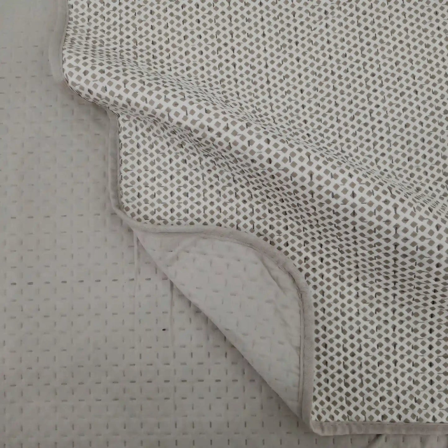 Detalle de la esquina de la colcha reversible estampada con rombos