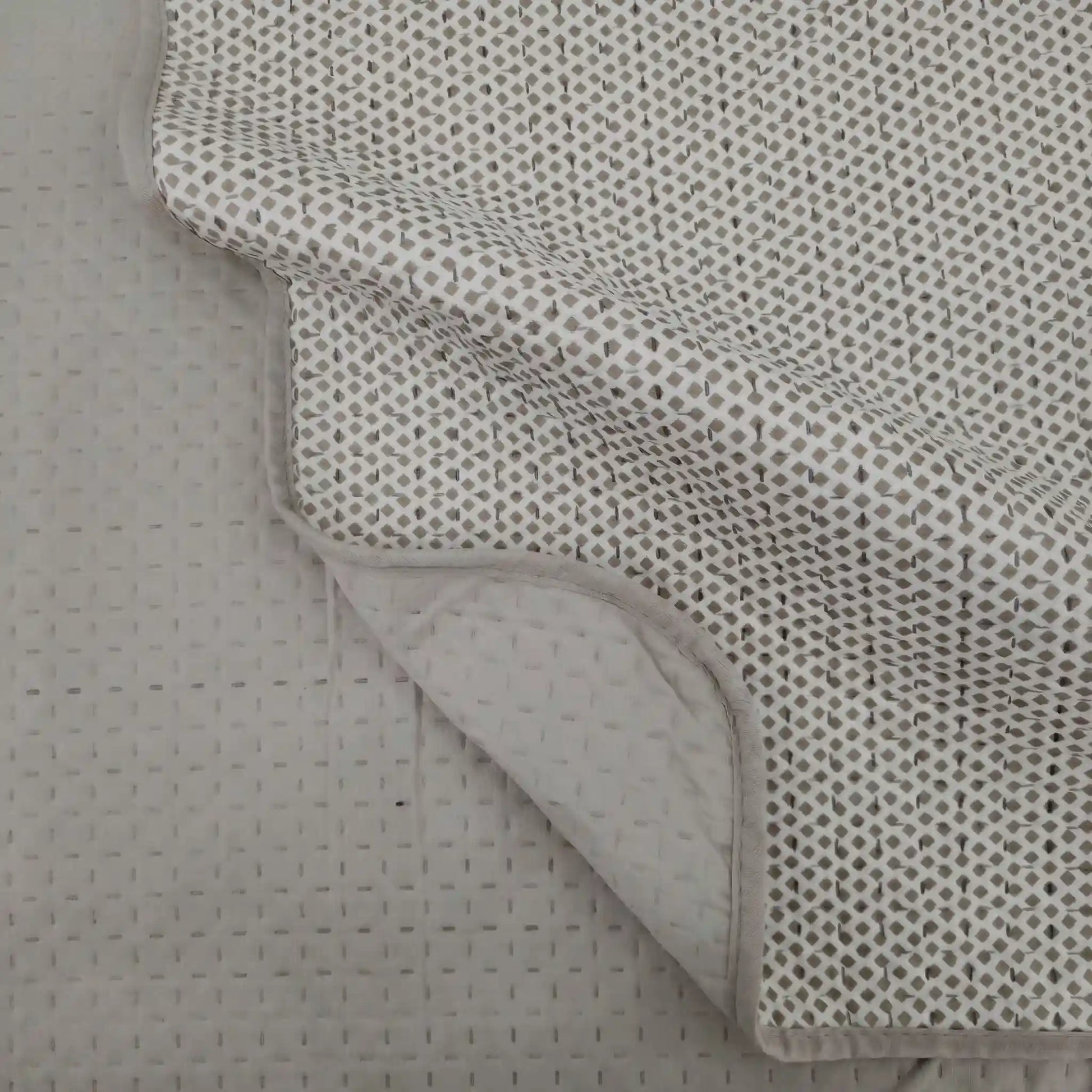 Detalle de la esquina de la colcha reversible estampada con rombos