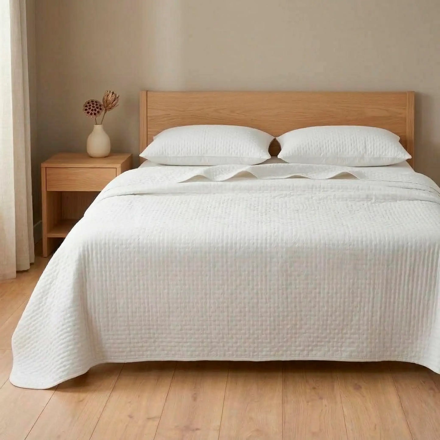 Cama de matrimonio vestida con colcha bouti blanca de verano aportando luminosidad