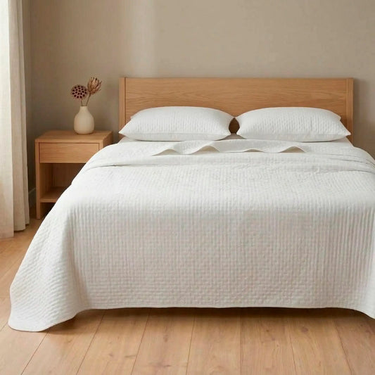 Cama de matrimonio vestida con colcha bouti blanca de verano aportando luminosidad