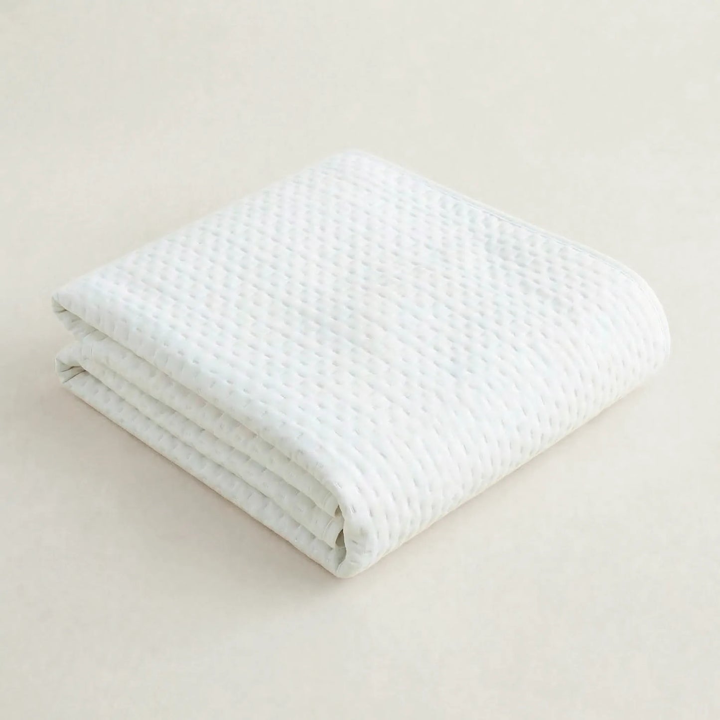 Primer plano de la textura, acolchado fino y costuras de la colcha blanca de estilo ibicenco