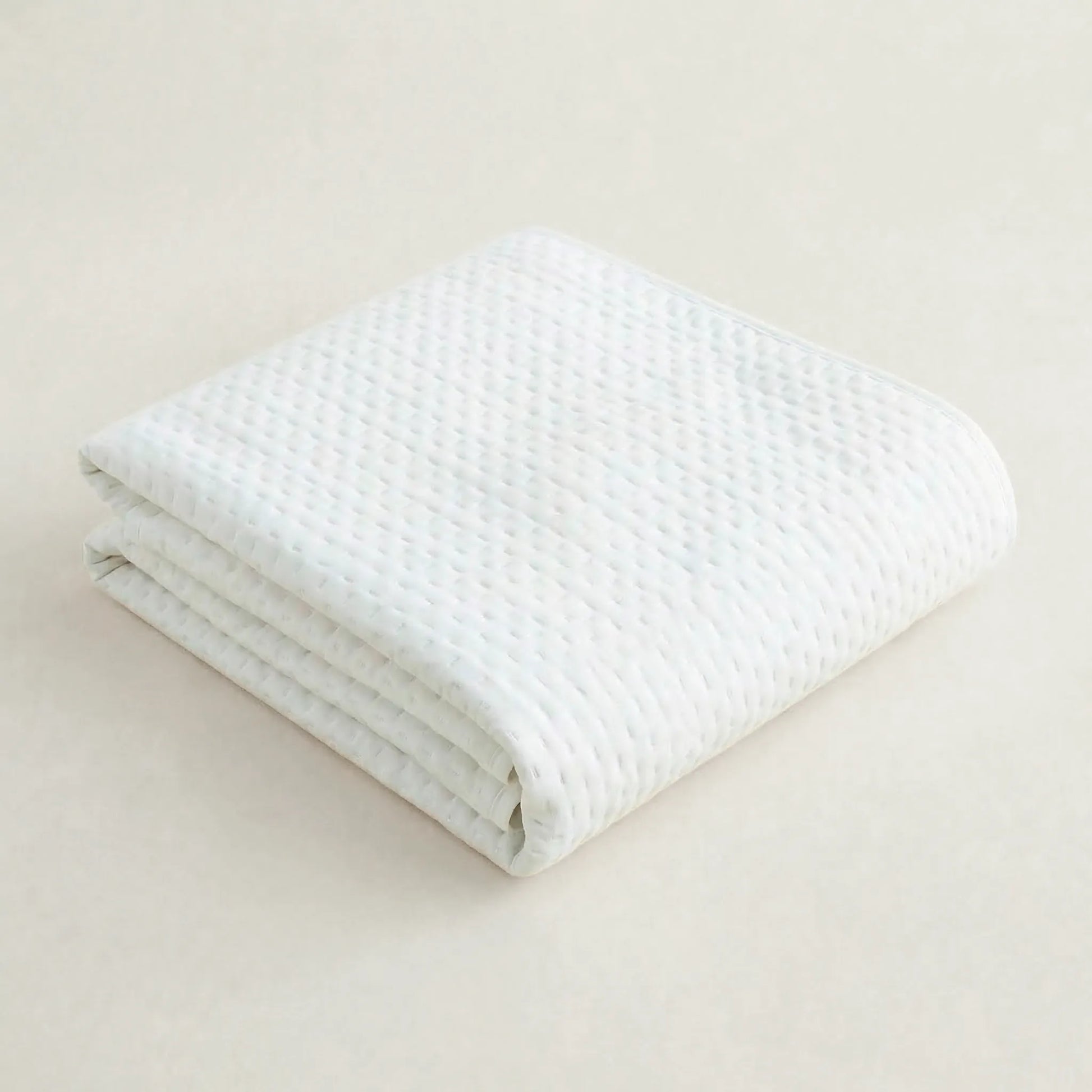 Primer plano de la textura, acolchado fino y costuras de la colcha blanca de estilo ibicenco