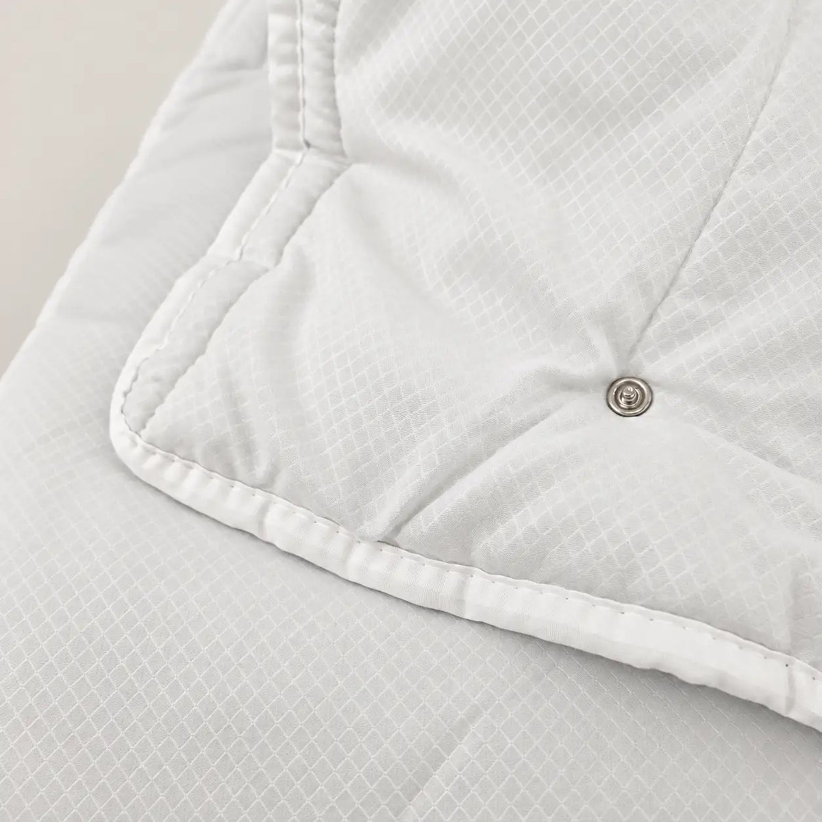Detalle del sistema de botones de corchete del relleno nórdico Eco para unirlo al modelo de 100gr y crear un edredón 4 estaciones.
