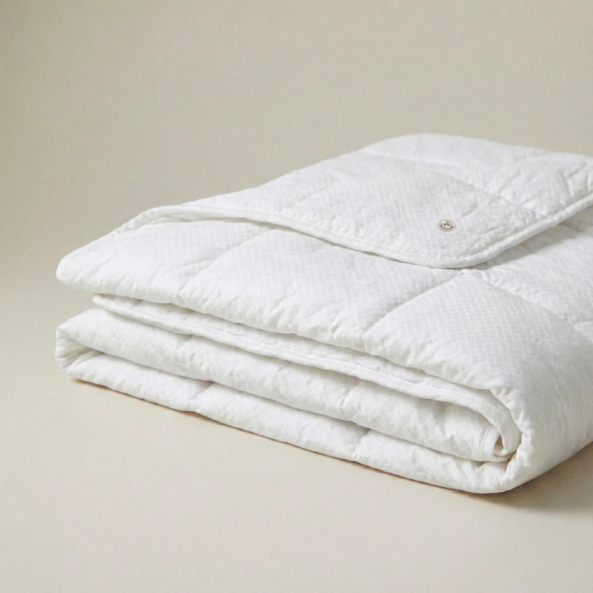 Detalle de los corchetes de unión en la esquina del relleno nórdico de 100gr, diseñados para engancharse al modelo de 250gr y crear un edredón 4 estaciones.