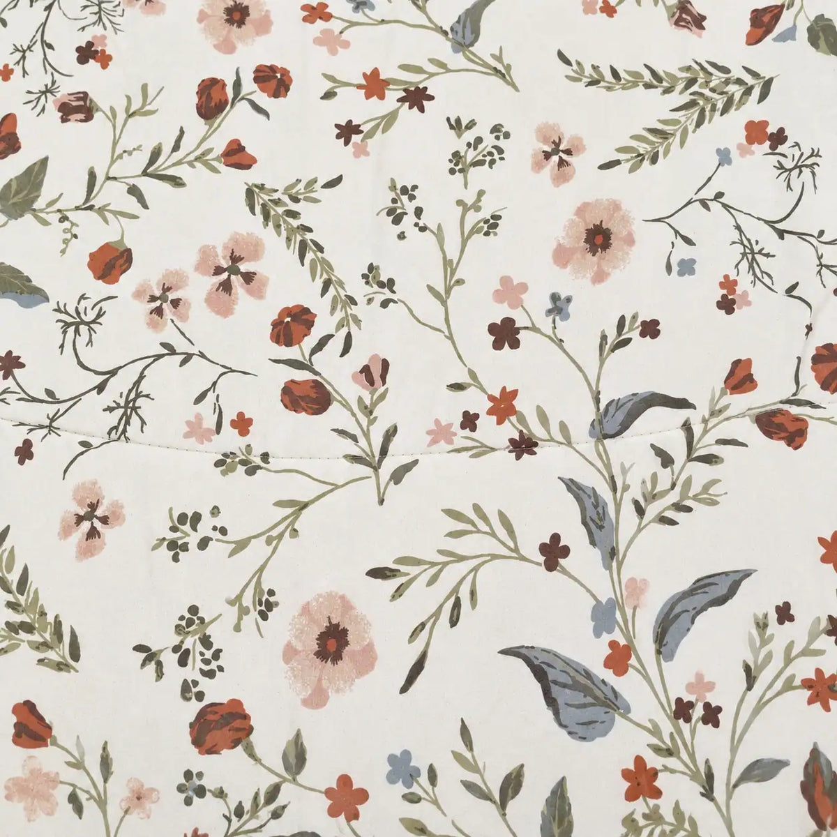Primer plano del estampado floral del edredón, con detalles de hojas y flores en tonos cálidos y tierra sobre fondo claro.