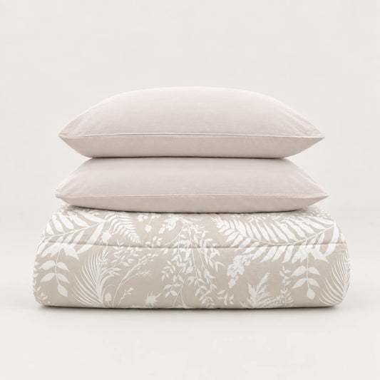 Beige winter duvet with a white leaf print, neatly folded with two matching pillowcases.