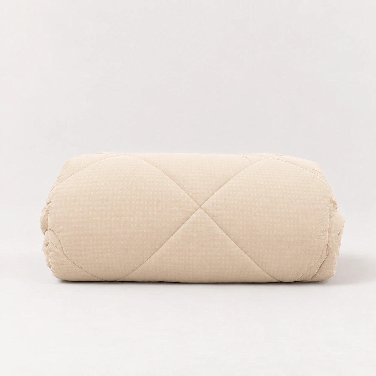 Edredón nórdico beige de microfibra perfectamente doblado, ideal para aportar calidez, luz y un estilo neutro a tu dormitorio.