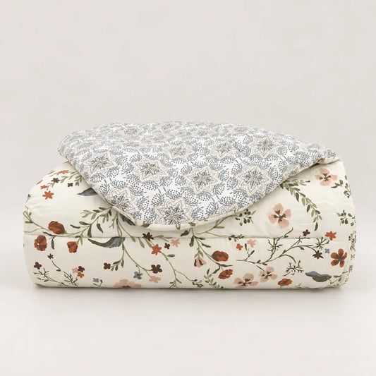 Mid-season duvet neatly folded, showing wildflowers on the front and a geometric pattern on the reverse.