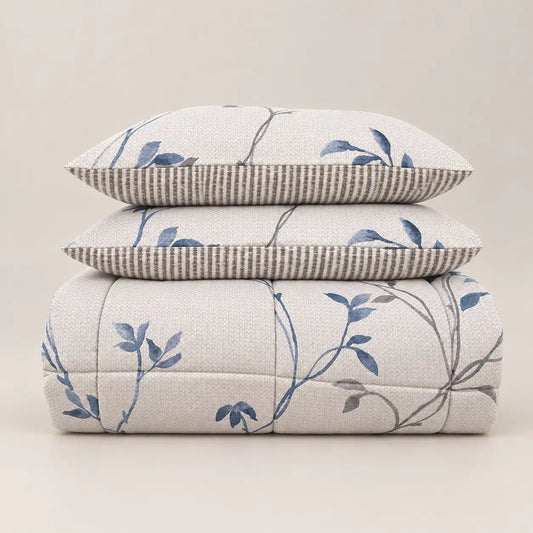 Winter duvet with a blue floral print and striped reverse, neatly folded with two matching pillowcases.