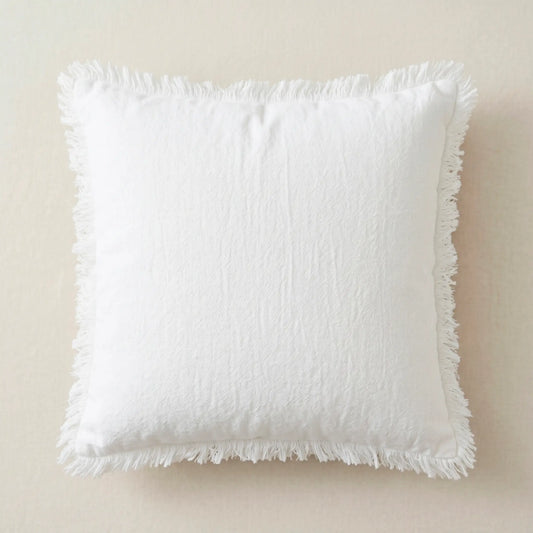 Funda de cojín blanca 45x45cm de 100% algodón con detalles de flecos de Oma Home. Diseño puro y luminoso para sofá.