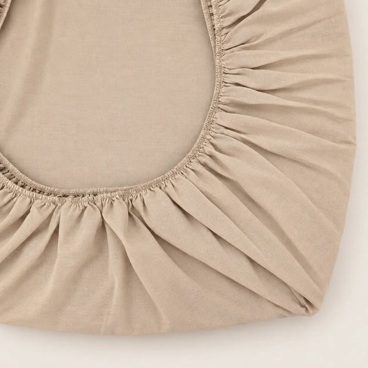 Close-up of the elasticated corner of the stone brown fitted sheet. - Oma Home